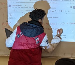 student doing equations on white board