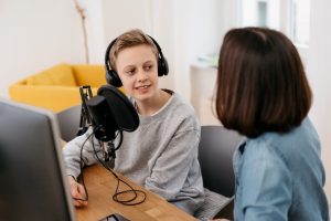 two students podcasting with mic