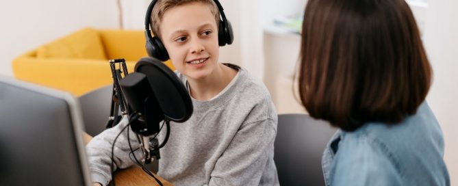 two students podcasting with mic