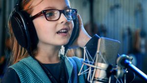 young girl using mic to podcast