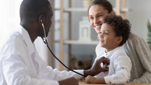 Doctor checking child's heart beat